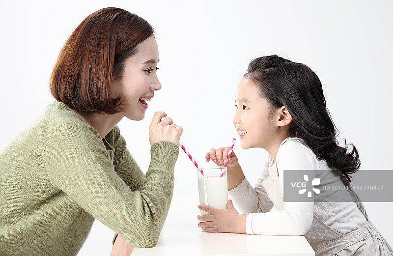 母亲和女儿喝着牛奶图片素材