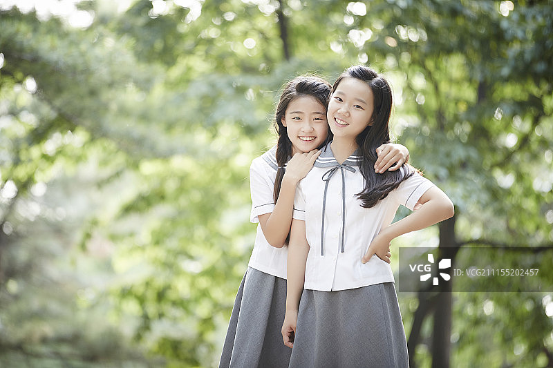 照片中的两个十几岁的女孩站在森林里图片素材