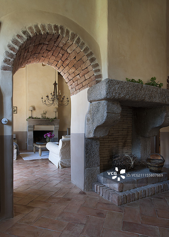 壁炉旁边是通向客厅的拱形石砌门洞图片素材