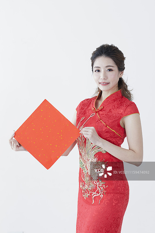 年轻女人穿旗袍拿着春联图片素材