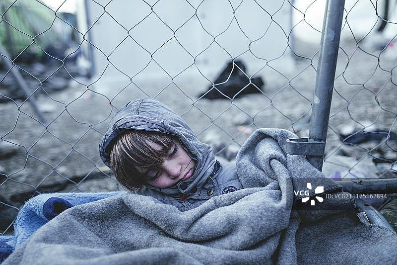 欧洲希腊马其顿中部的伊多梅尼难民营，阿富汗男孩睡在检查站附近图片素材
