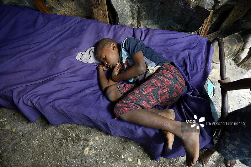 2010年地震发生5年后，中美洲海地太子港的国家堡，一名男孩睡在营房的床上图片素材