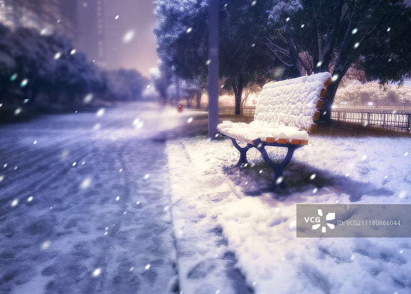 下雪天夜晚灯光下长凳上的积雪图片素材