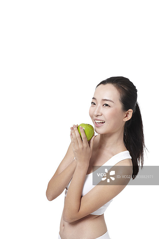 穿着运动服拿着苹果的女人的照片图片素材