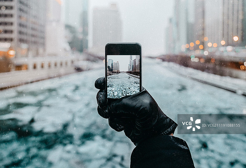 冬季城市中手持手机的特写镜头图片素材