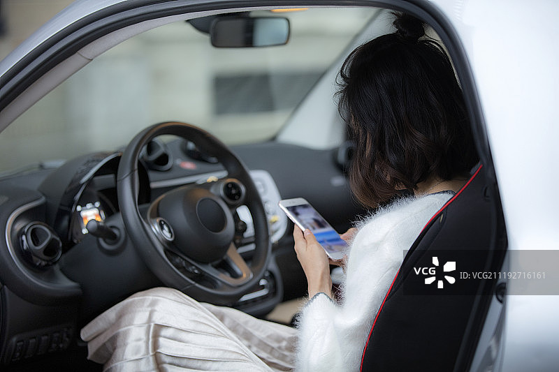 年轻女性在车中使用手机图片素材