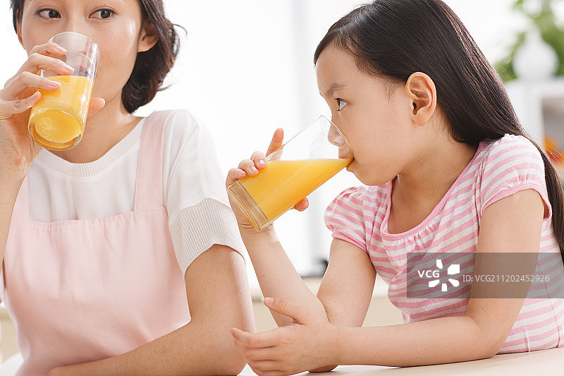 母亲和女孩在喝果汁图片素材