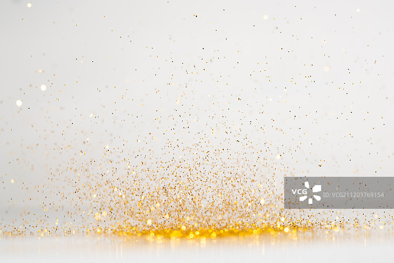 高速跳动的金粉失焦白底棚拍广告创意设计素材图片素材