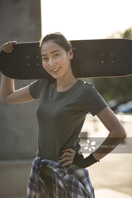 青年女子在户外拿着滑板准备运动图片素材