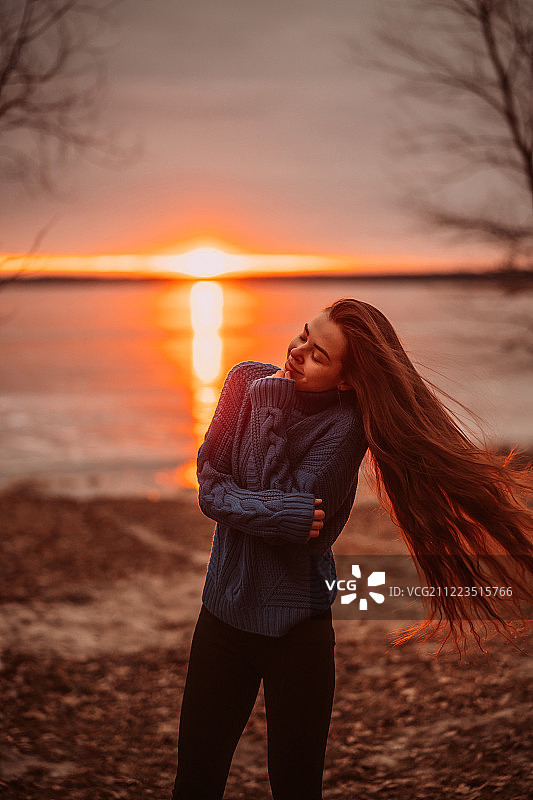 女人享受时间放松在美丽的湖在日出图片素材
