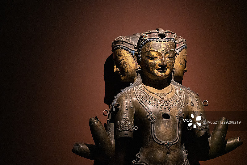 甘肃敦煌莫高窟博物馆里的三头佛像铜质展览品图片素材