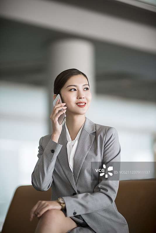 年轻商务女士在机场候机室打电话图片素材