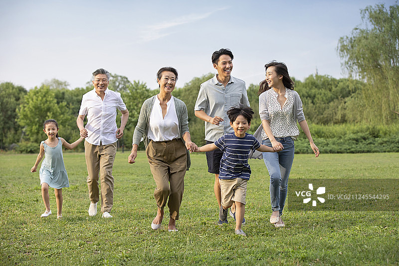 快乐家庭在草地上奔跑图片素材