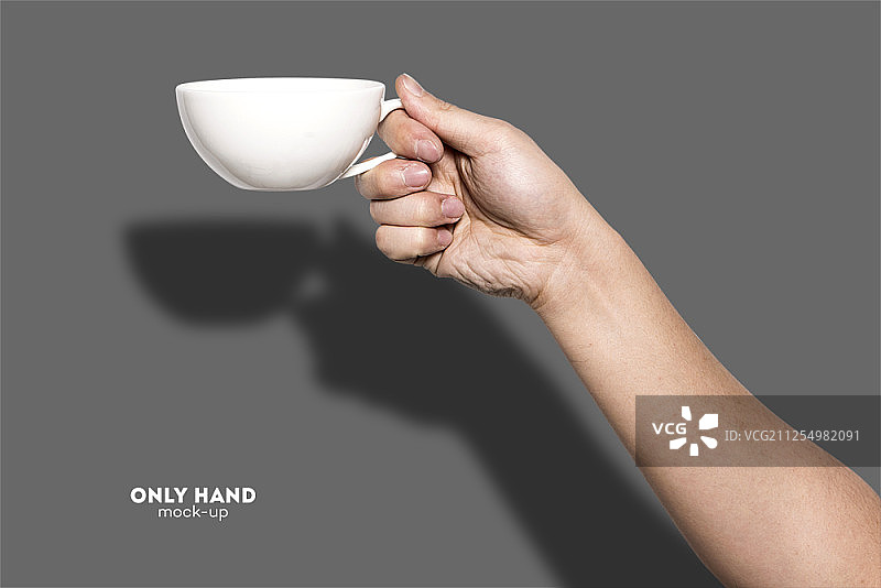 手握一个咖啡杯，孤立在一个灰色的背景图片素材