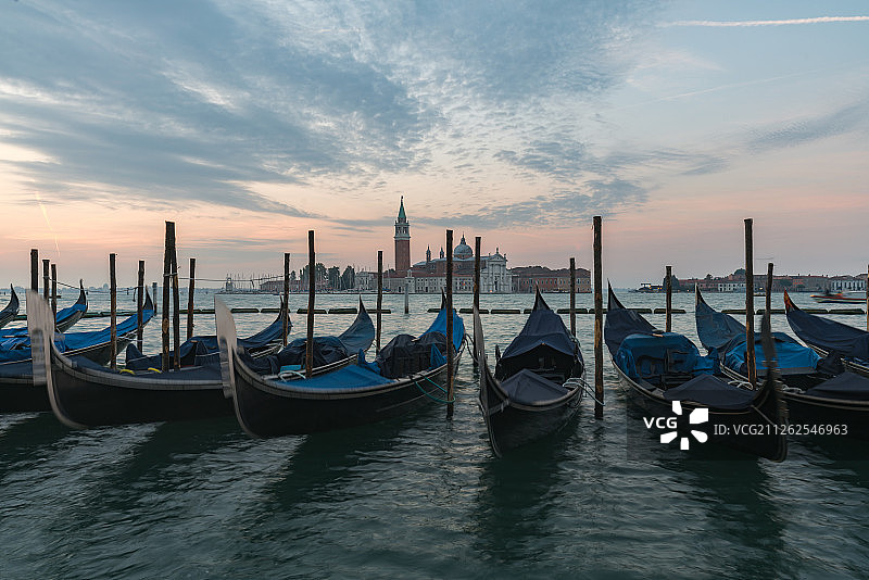 意大利威尼斯运河日出和海面上的贡多拉图片素材
