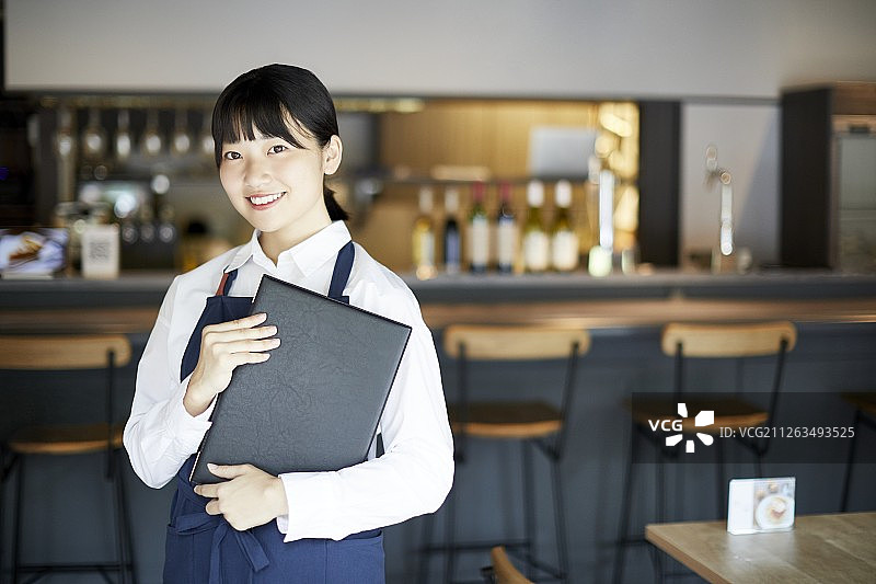 在餐馆工作的年轻日本女人图片素材