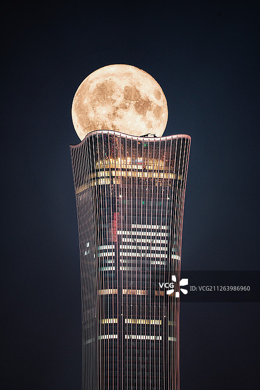 中秋节北京中国尊建筑穿过月亮图片素材