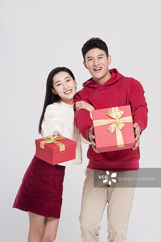 快乐的情侣拿着礼物盒庆祝新年图片素材