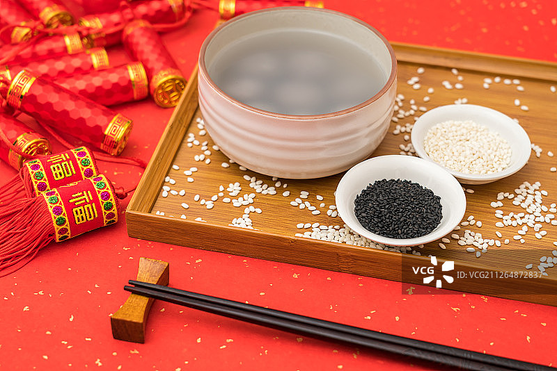 红色背景下的中国传统美食黑芝麻汤圆图片素材