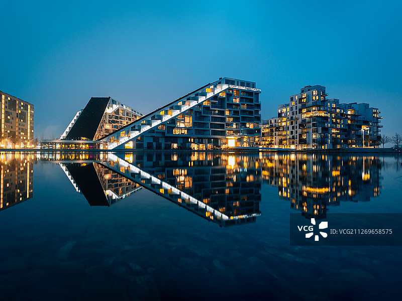 灯光映照在丹麦坦恩比河上的城市图片素材