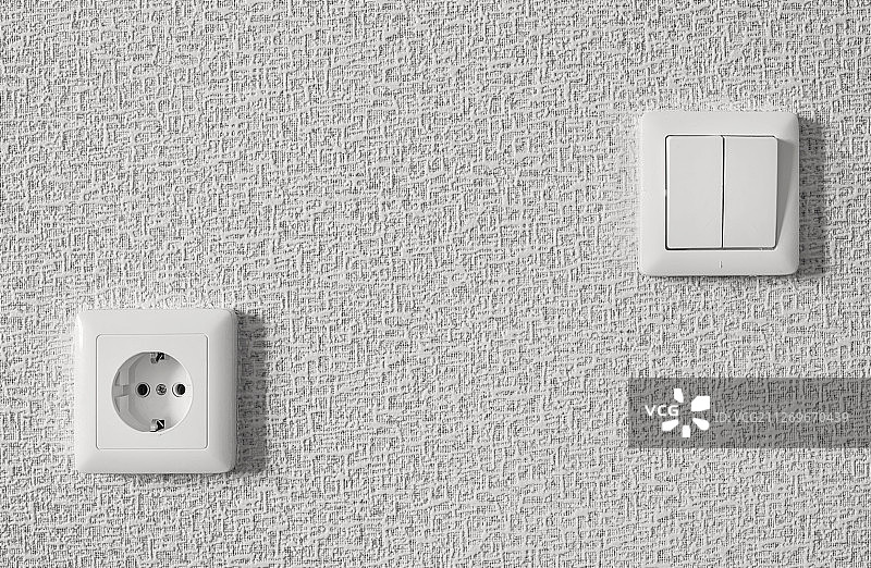 白色墙壁上的电灯开关和插座图片素材