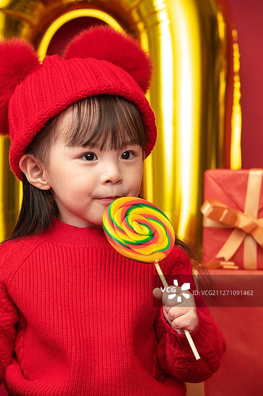 过新年的小女孩吃棒棒糖图片素材