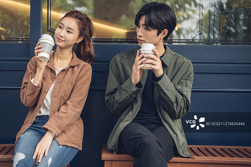 夫妻坐在商店前喝咖啡的照片图片素材