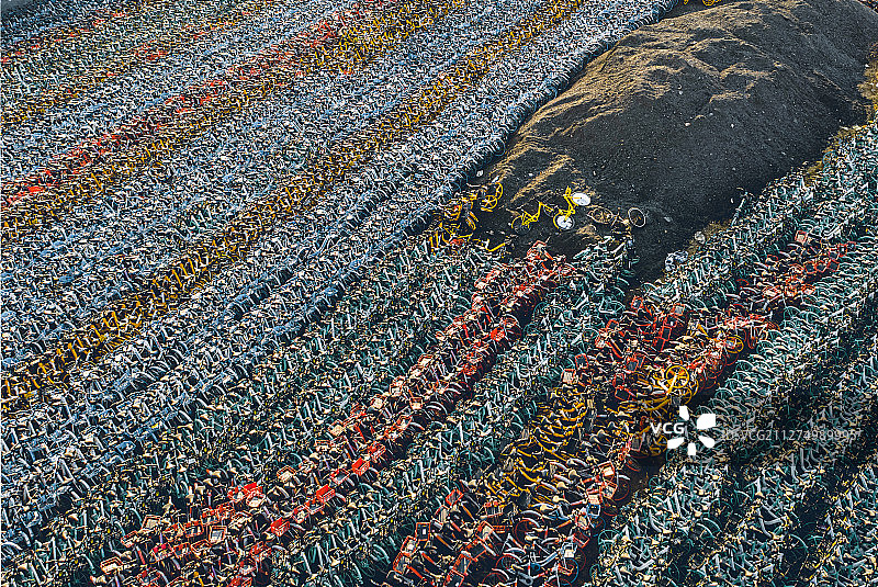 大量排列紧密整齐的荒废的多种颜色共享单车停车场图片素材