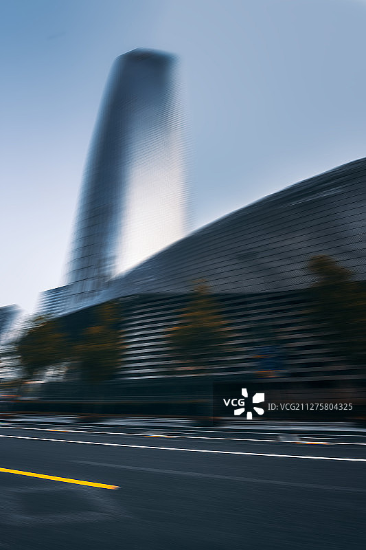 运动模糊的都市现代建筑摩天大楼和柏油路水平视角图片素材