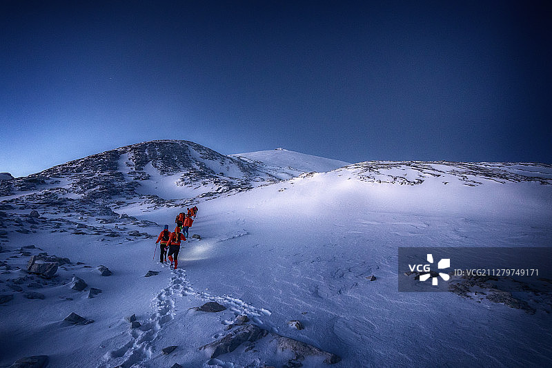 黎明时分，一个攀登小分队正在向海拔5396米的雪山顶峰进发图片素材