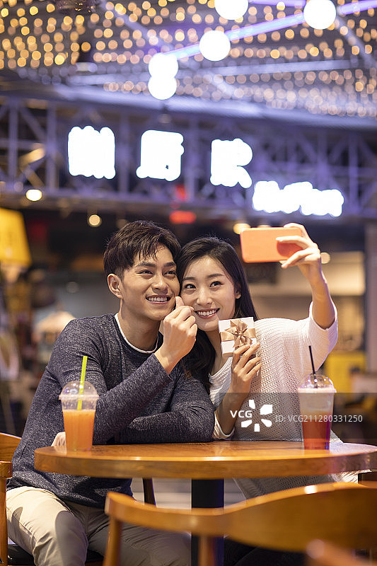 快乐的年轻情侣在商场自拍图片素材