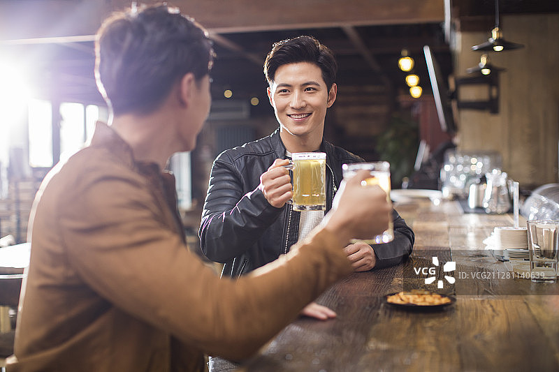 快乐的年轻男士在酒吧喝酒图片素材