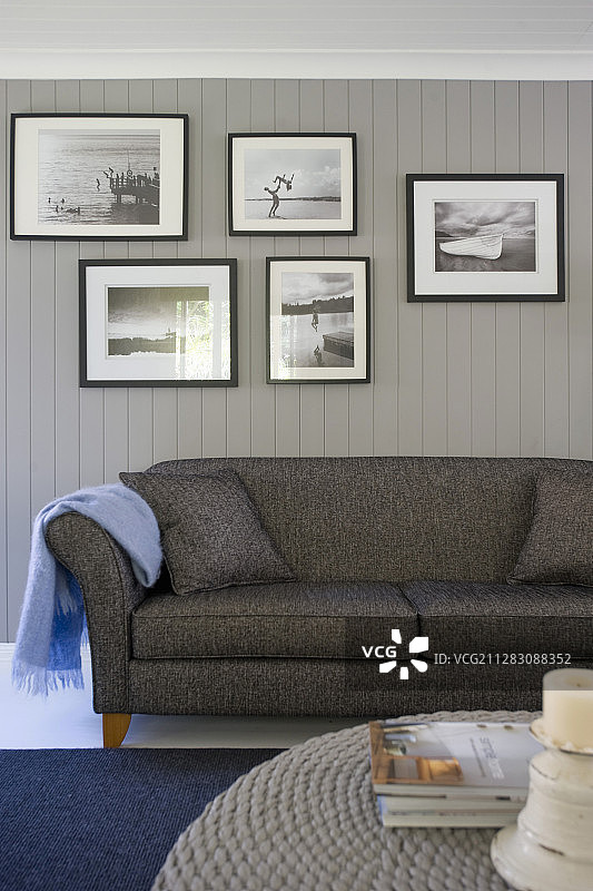灰色沙发上方的黑白照片画廊图片素材