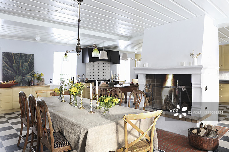 大型乡村别墅厨房餐厅，餐桌旁边是开放式壁炉图片素材