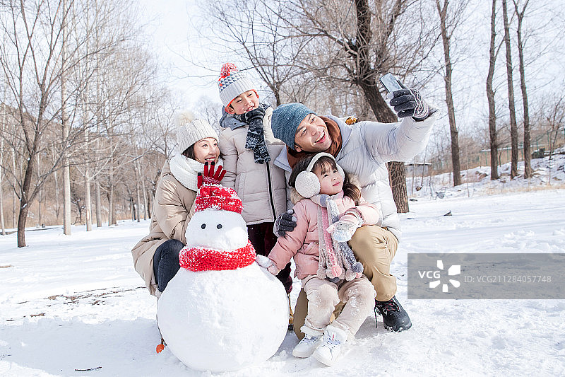 欢乐家庭在雪地里堆雪人图片素材