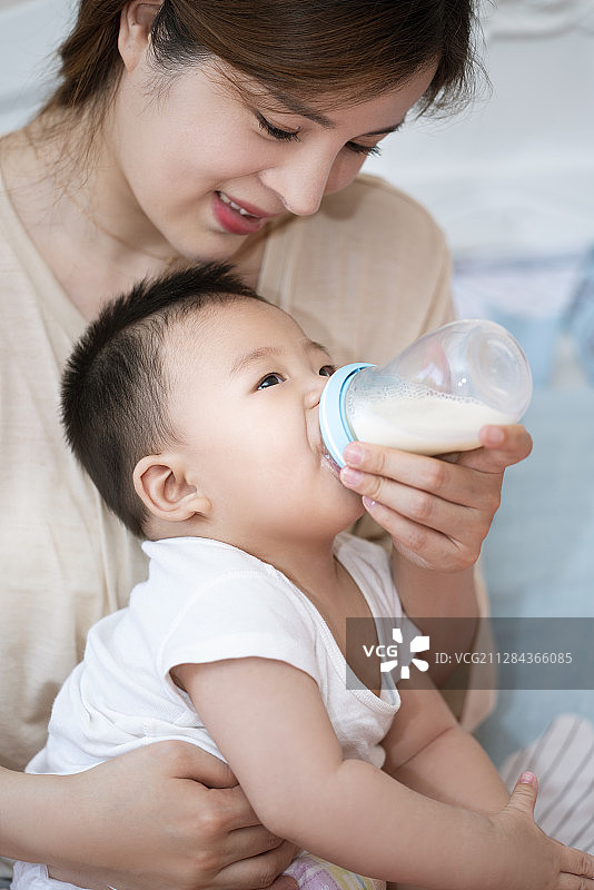 年轻妈妈给婴儿喂奶图片素材