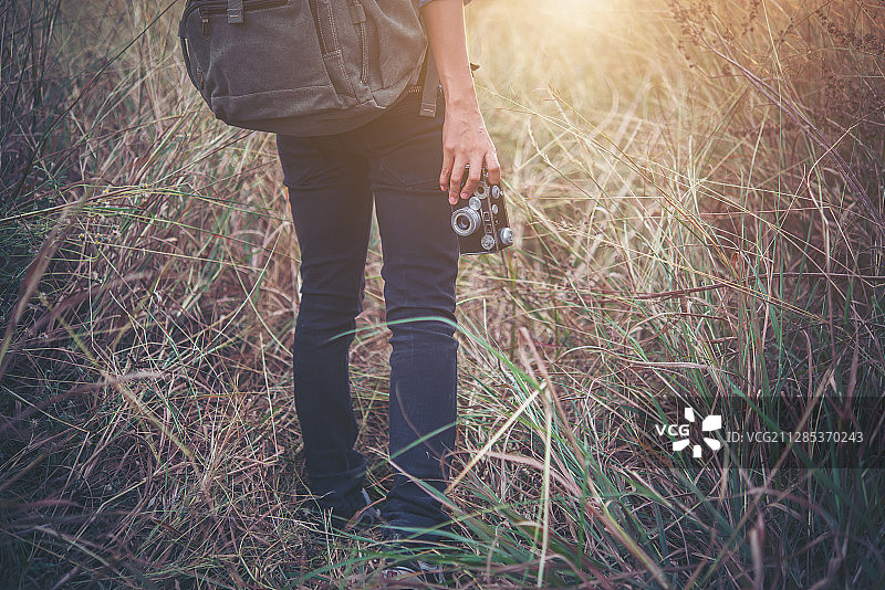 背着背包的女人站在野外，拿着相机图片素材