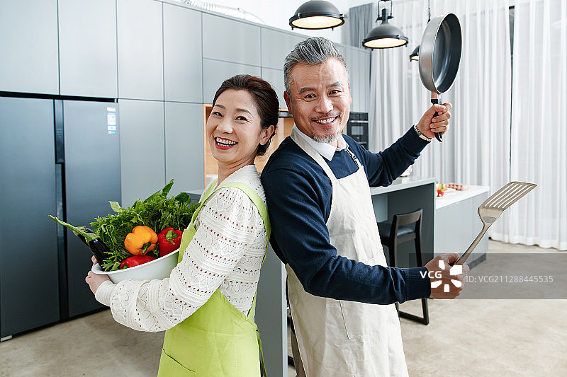 快乐的中老夫妇在厨房做饭图片素材