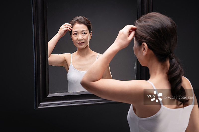 中年女性欣赏镜子中的自己图片素材