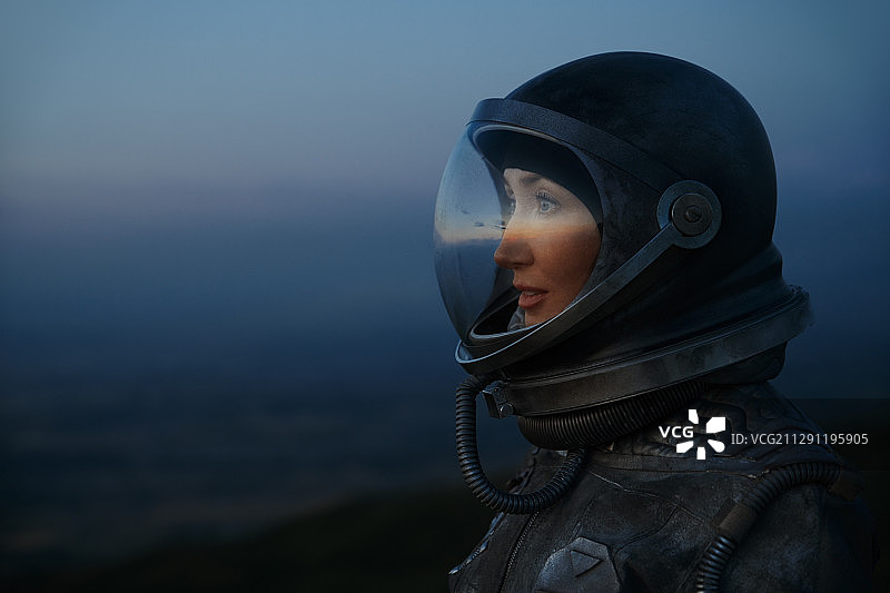 在日落时穿着宇航服和头盔的女宇航员图片素材