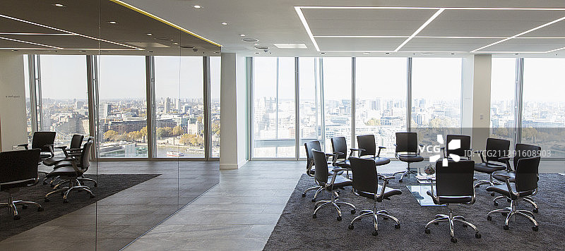 现代化的高层会议室里，椅子围成一圈图片素材