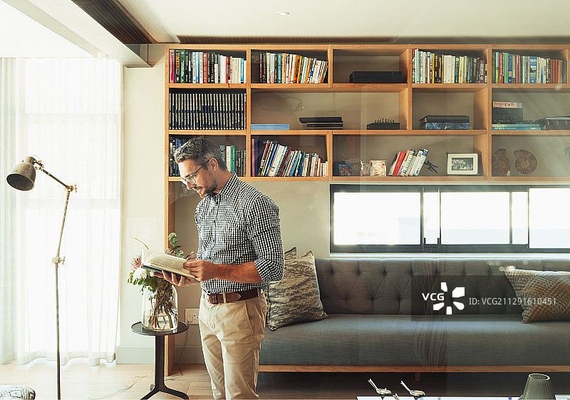 男人在现代的客厅里读书图片素材