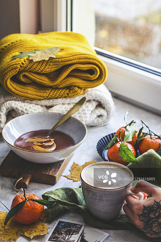 秋天的气候，咖啡在手，暖和的毛衣背景，巧克力布丁与桔子奶油图片素材