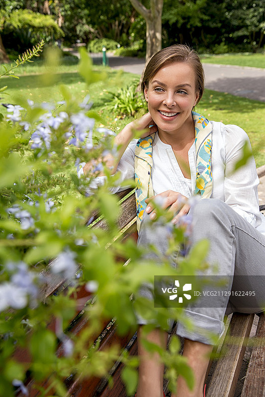 在公园长椅上放松的快乐女人图片素材