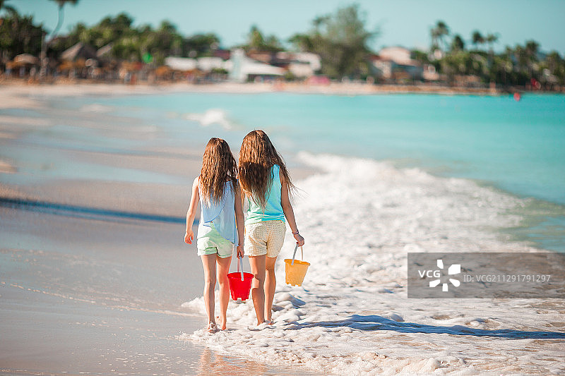 可爱的小妹妹们在暑假的海滩上散步图片素材