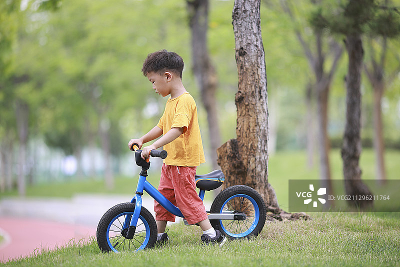 公园里学骑车的小男孩图片素材