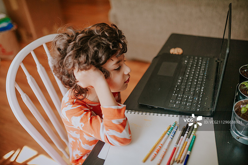 加拿大维多利亚，男孩在家里使用笔记本电脑进行在线学习的高角度视图图片素材