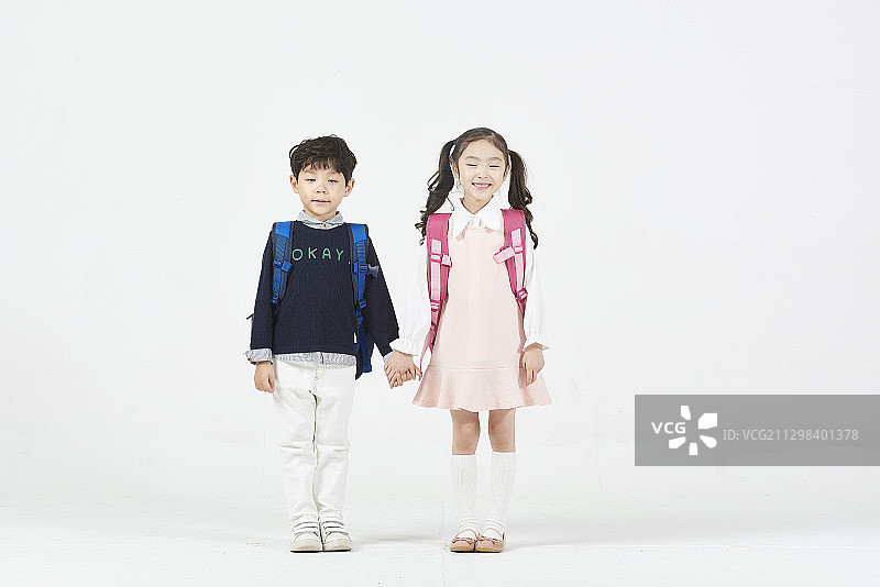 男孩和女孩背着背包，他们的手放在白色的背景上图片素材