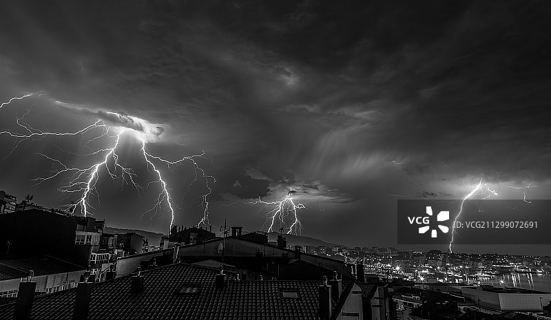 全景的闪电在夜空下照亮城市景观，Vigo，西班牙图片素材