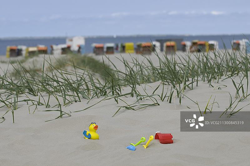 假期，孩子们的玩具在沙丘前的一个有屋顶的藤条沙滩椅上的海滩和大海，诺德代奇，诺登，东弗里斯兰，下萨克森，德国，欧洲图片素材